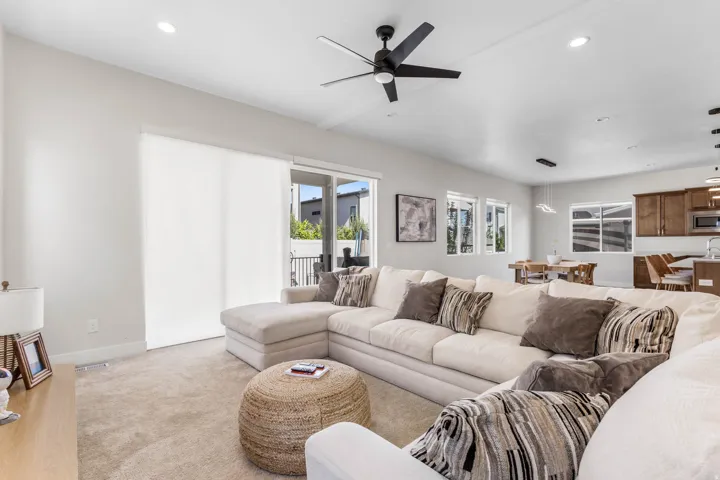 Spacious living area with recessed lighting, ceiling fan, and carpeted flooring