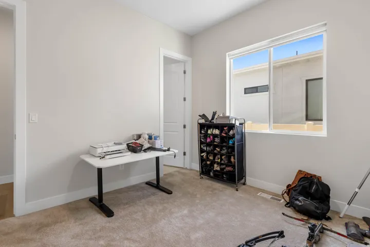 Carpeted room featuring light gray wall paint, white trim, and a sliding window