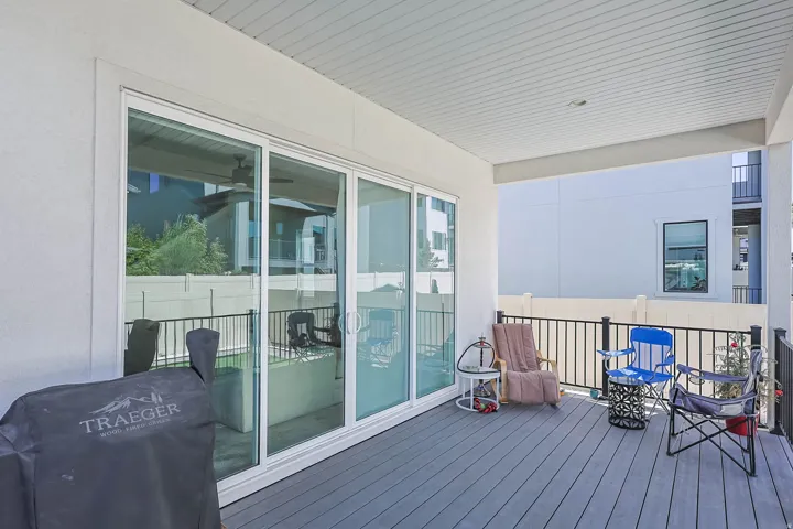 Covered balcony featuring composite decking and black metal railings