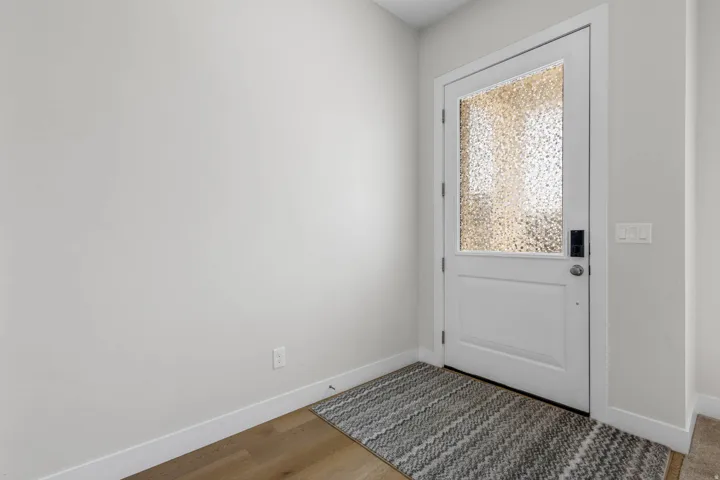 White entry door with textured glass panel and smart lock
