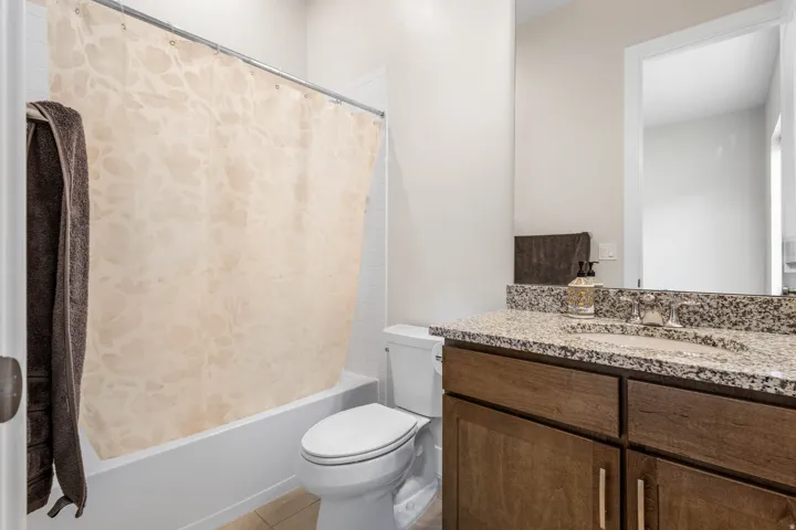Built-in vanity with a speckled countertop, integrated sink, and wood-finish cabinetry