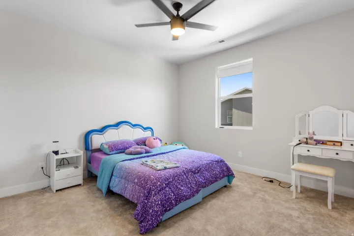 Recessed lighting, ceiling fan with integrated light, neutral carpet flooring, and a single window with a roller shade