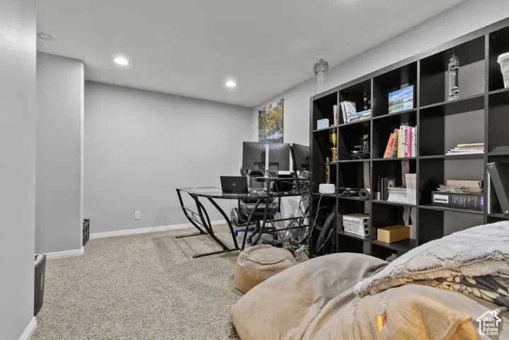 Recessed ceiling lighting, light gray wall paint, carpeting, and a built-in shelving unit
