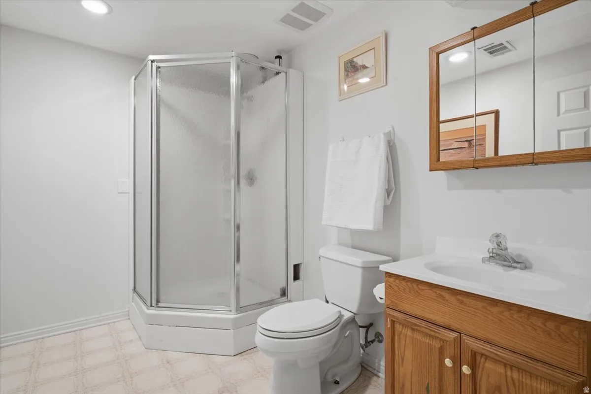 Bright bathroom featuring a corner shower enclosure with frameless glass doors, white subway tile surround, and chrome hardware