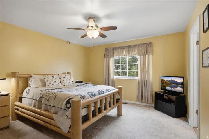 Recessed window with exterior views, ceiling fan with integrated lighting, and carpet flooring
