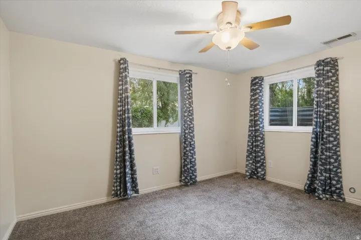 Recessed ceiling fan, textured ceiling, two windows, wall-to-wall carpeting, and neutral wall tones