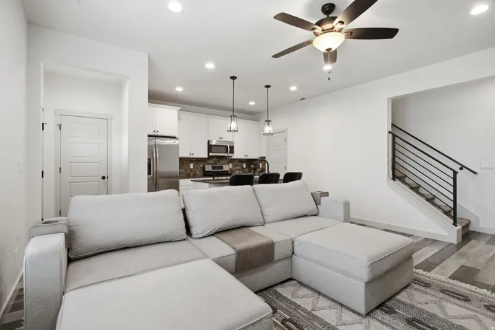 Open-concept living area featuring wood-finish flooring, recessed lighting, and a contemporary ceiling fan