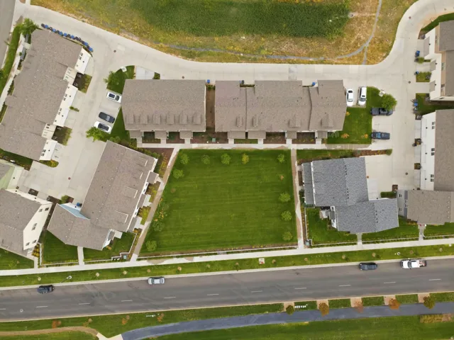 Community featuring a central green space, paved roads, and multiple residential buildings