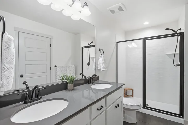 Dual vanity with integrated sinks, dark countertop, and matte black fixtures