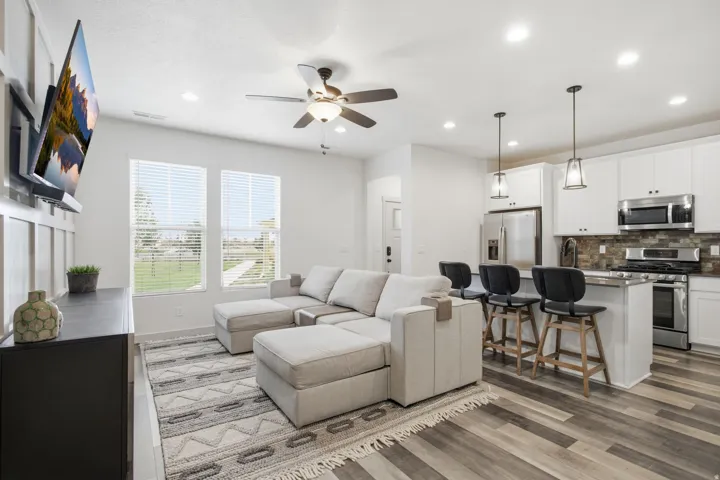 Open-concept living area featuring wood-finish flooring, recessed lighting, and a ceiling fan