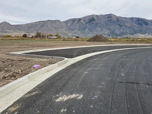 Freshly paved asphalt road with a newly installed concrete curb