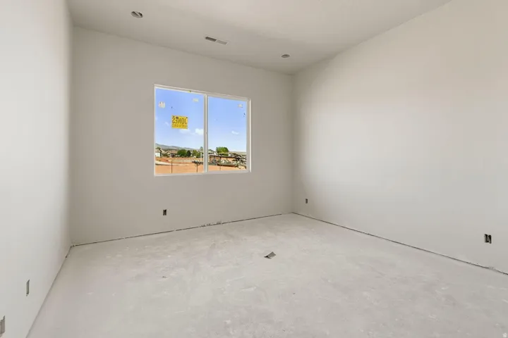 Spacious room with unpainted walls, recessed ceiling lighting, and a large window
