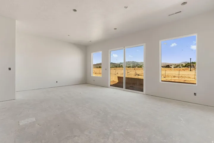 Expansive interior with light-toned walls, recessed lighting, concrete flooring, and multiple windows
