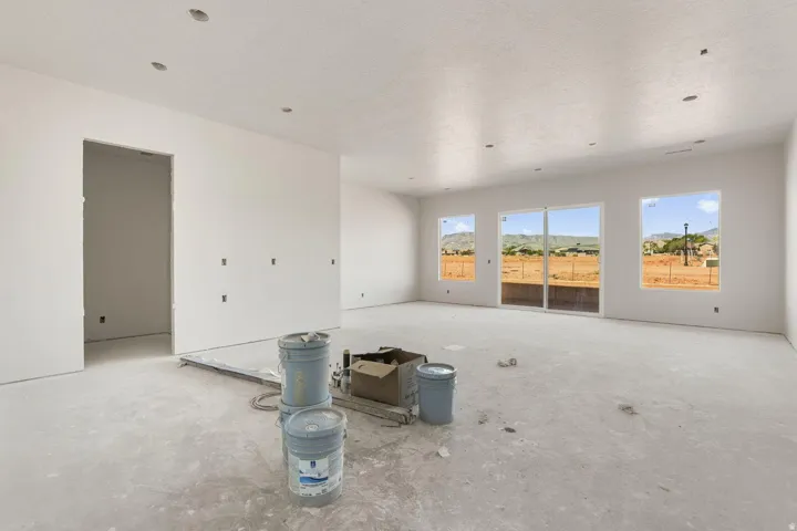 Spacious unfinished interior featuring multiple windows, a sliding glass door, and recessed lighting