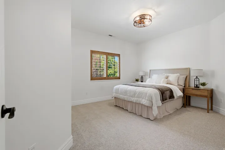 Neutral tone wall finish with a large window featuring wood shutters
