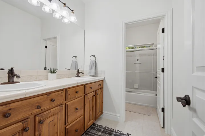 Double vanity with wood cabinetry, two undermount sinks, and bronze-finish faucets