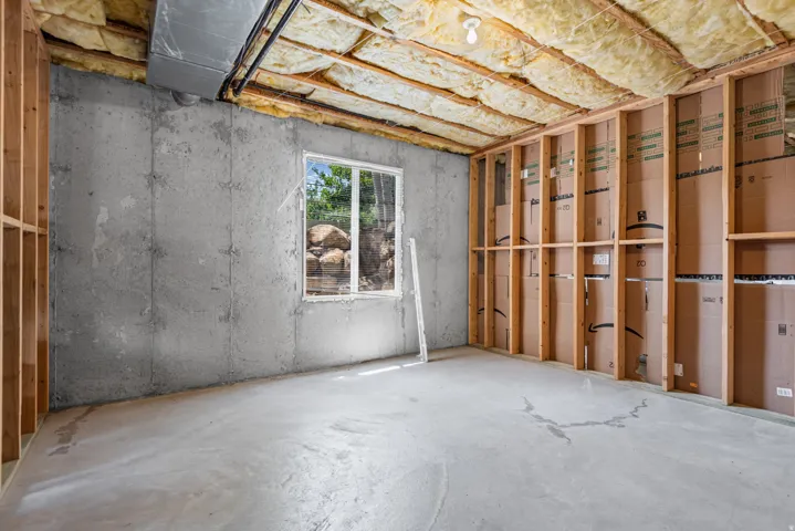 Unfinished basement with concrete flooring, framed walls, and an insulated ceiling