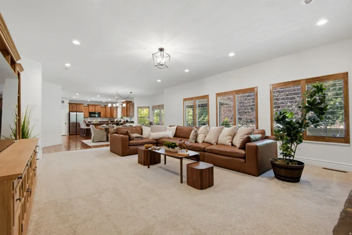 Expansive living area with recessed lighting and a central decorative fixture