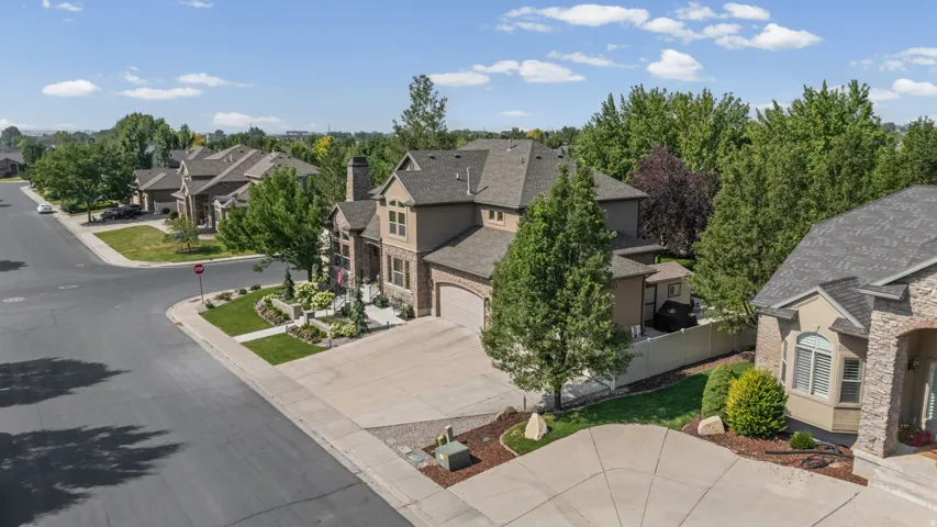Siding exterior with brick accents, attached garage, and mature landscaping
