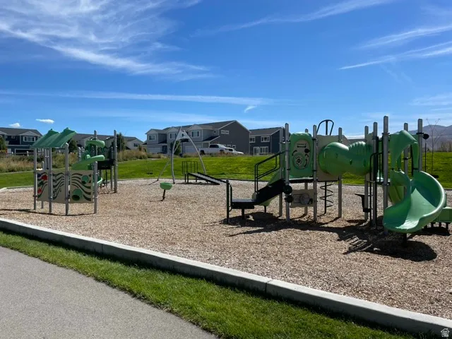 Playground area featuring multiple slides, swings, and climbing structures on a wood chip surface