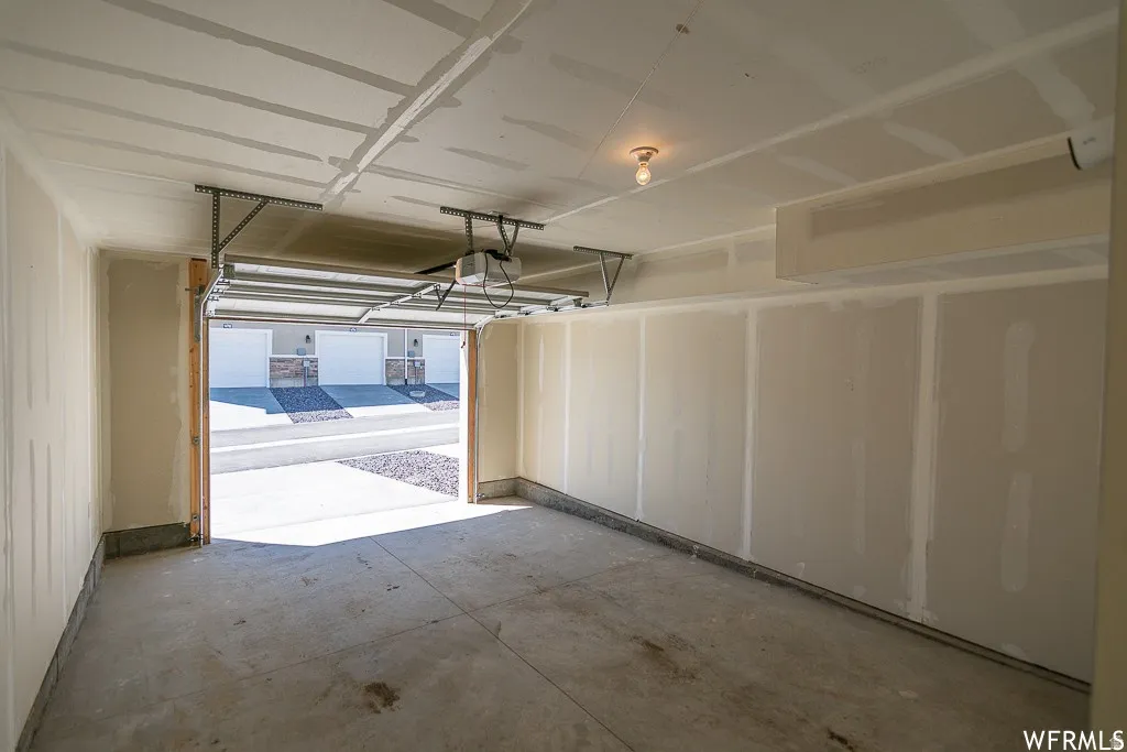 Attached garage with concrete flooring, automatic garage door opener, and overhead lighting