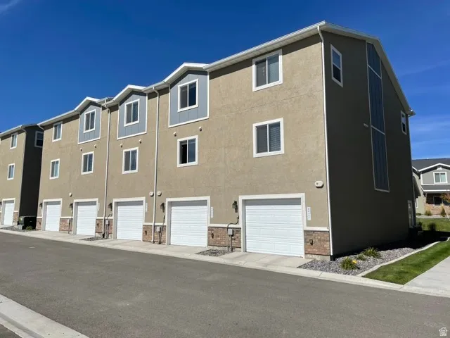 Multi-story exterior with stucco siding and architectural dormers