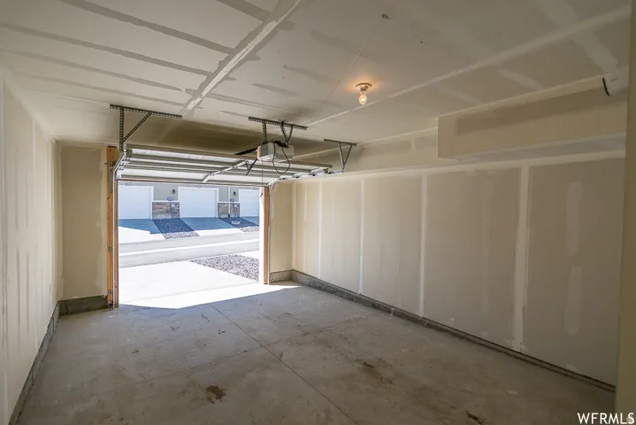 Attached garage with concrete flooring, automatic garage door opener, and overhead lighting
