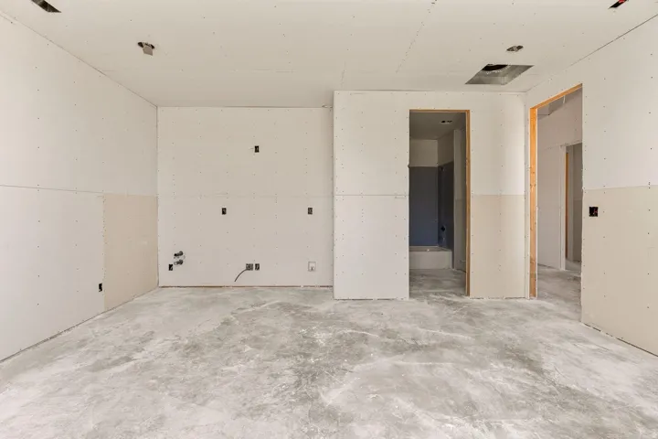 Unfinished interior space featuring drywall, exposed wiring, and concrete flooring