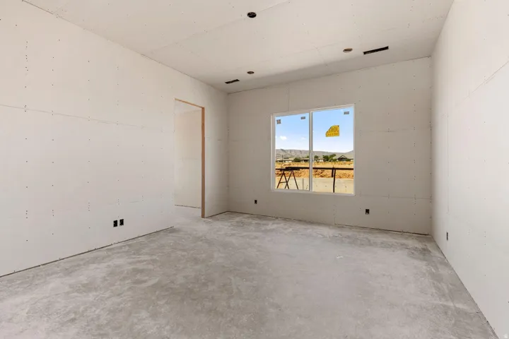 New construction interior with unfinished drywall, concrete subfloor, recessed lighting, and a dual-pane window