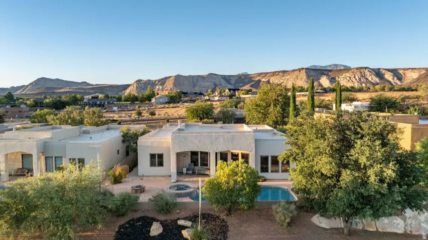 Southwestern-style architecture with stucco exterior, multiple window openings, and an outdoor pool