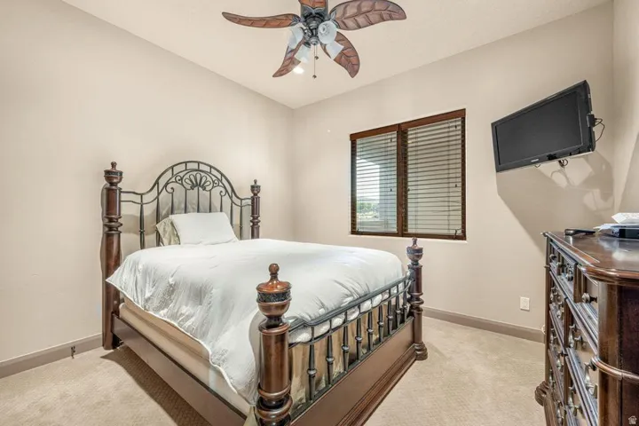 Carpeted flooring with a contrasting trim, window with blinds, and ceiling fan