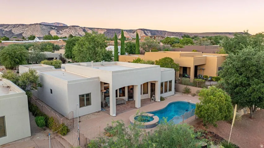 Flat-roof architectural style with a private patio area, an in-ground swimming pool, and an integrated hot tub