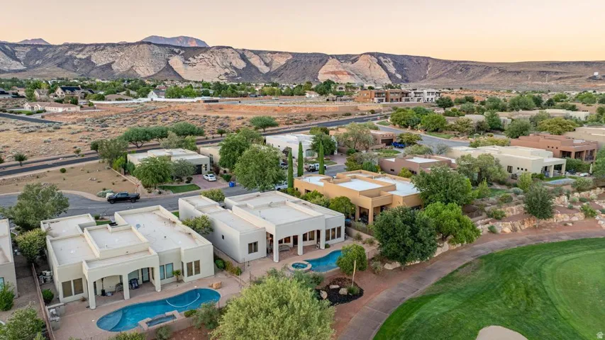 Expansive residential community with golf course access, featuring stucco exteriors, multiple private swimming pools, and extensive desert landscaping