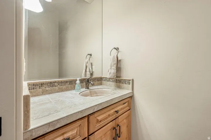 Wood-finish vanity with paneling and dark hardware