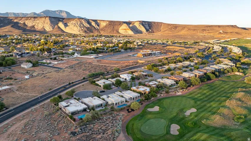 Mountainous backdrop with a golf course, residential properties, and surrounding roads