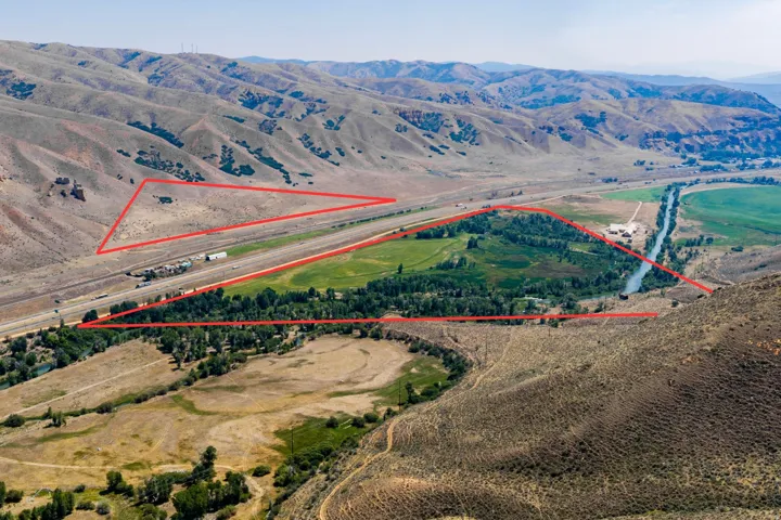 Expansive property featuring mountainous terrain, a river, and a highway