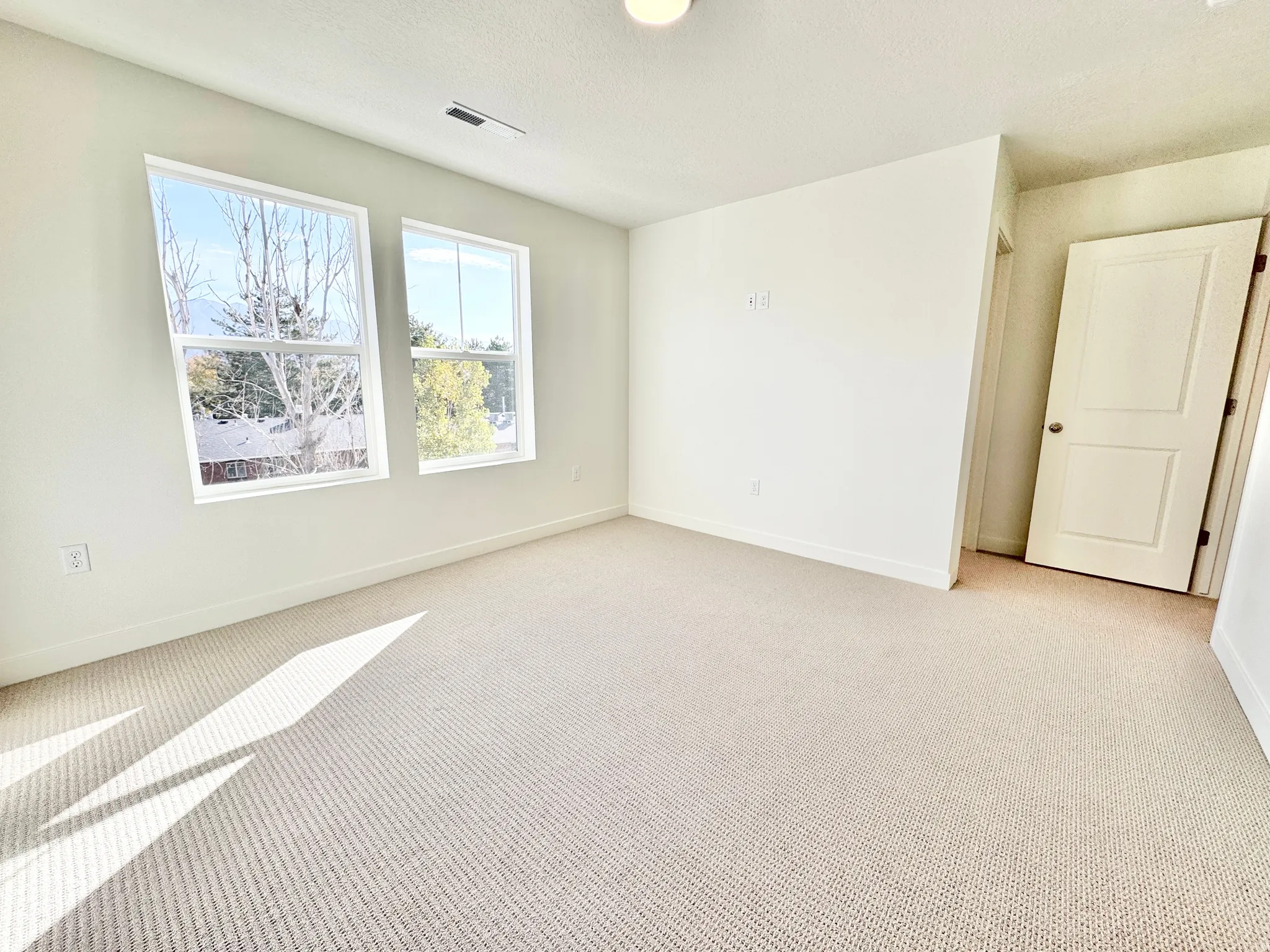 Wall-to-wall carpeting, dual windows, and an interior door with a two-panel design