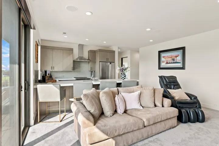 Open-concept living area with a contemporary kitchen, stainless steel appliances, modern cabinetry, and recessed lighting