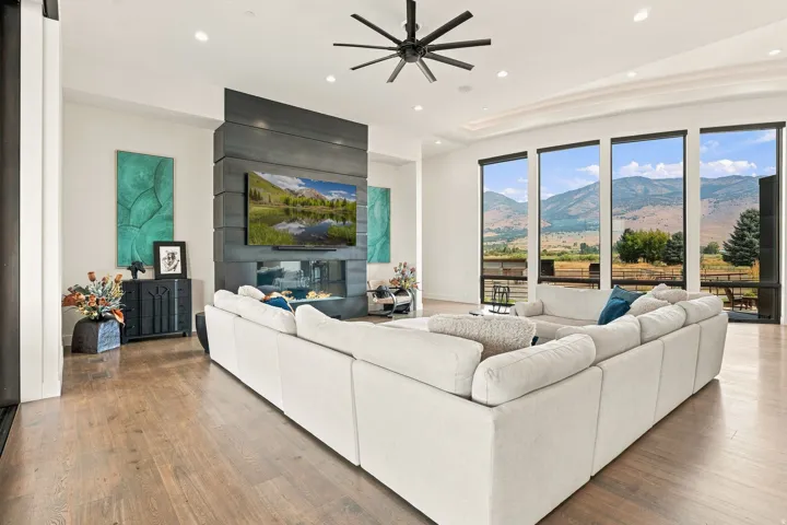 Hardwood flooring, linear gas fireplace, built-in media console, recessed lighting, and expansive windows