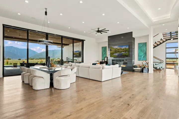 Expansive living area with wood-finish flooring, a contemporary fireplace, and a striking black feature wall