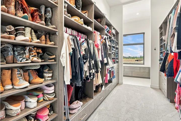 Expansive closet featuring extensive built-in shelving, hanging rods, integrated drawer storage, and a large window