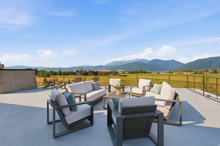 Expansive outdoor deck featuring a protective railing and distant mountain scenery