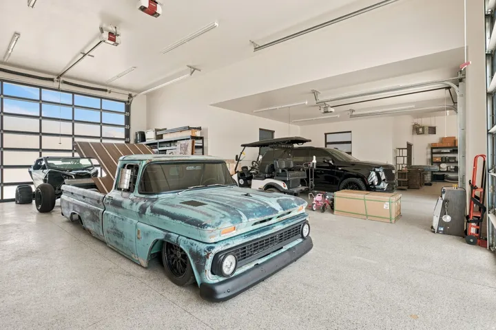 Spacious garage featuring a glass panel overhead door, high ceilings with track lighting, and durable speckled flooring