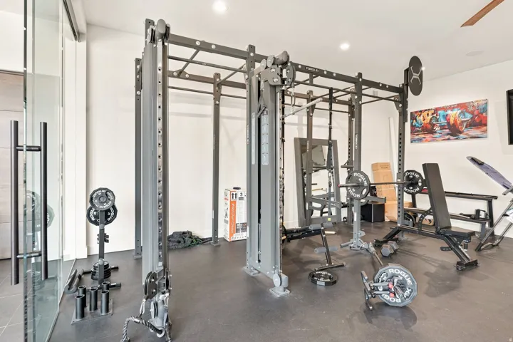 Dedicated fitness space with resilient flooring and recessed lighting