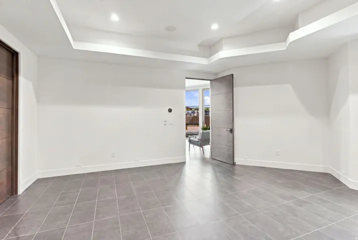 Recessed lighting, tray ceiling, large format tile flooring, and solid core doors