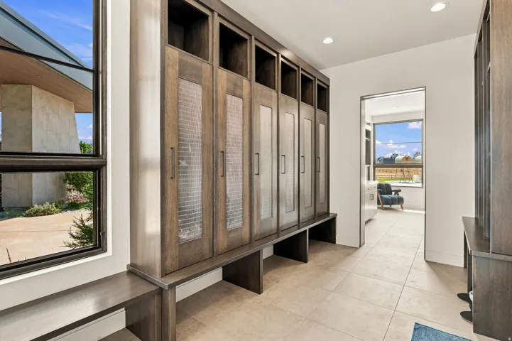 Built-in cabinetry with frosted panel doors, integrated bench seating, and recessed lighting