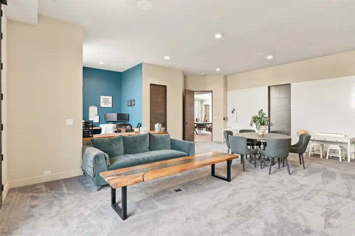 Recessed lighting, wall-to-wall carpeting, and a dedicated office space with a contrasting accent wall