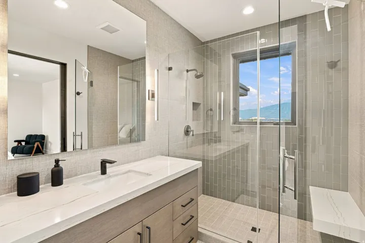 Glass-enclosed shower with a built-in bench, window, and rainfall showerhead