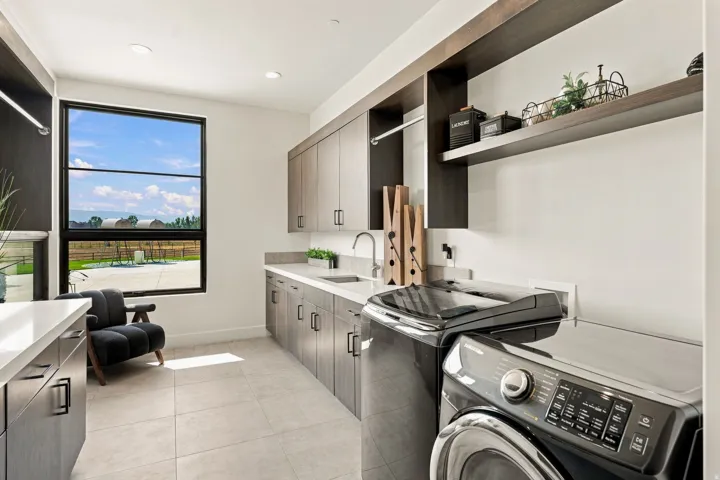 Large picture window, extensive cabinetry, light-toned countertops, integrated sink, and open shelving