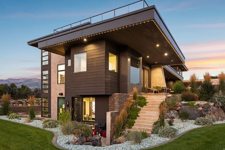 Modern exterior with multiple large windows, a flat roof, and a rooftop railing